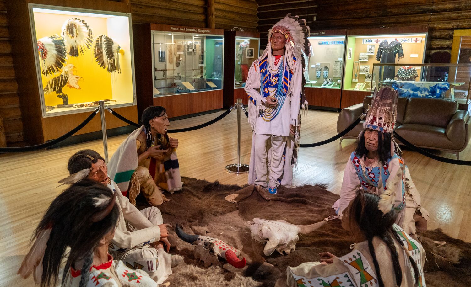 Artifacts and mannequins covered with traditional Indigenous clothing displayed at Buffalo Nations Museum in Banff National Park.